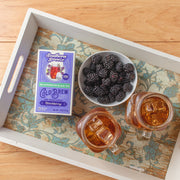 Southern Breeze Decaf Blackberry Sweet Iced Tea on a tray with jar of sweet tea and blackberries in a bowl