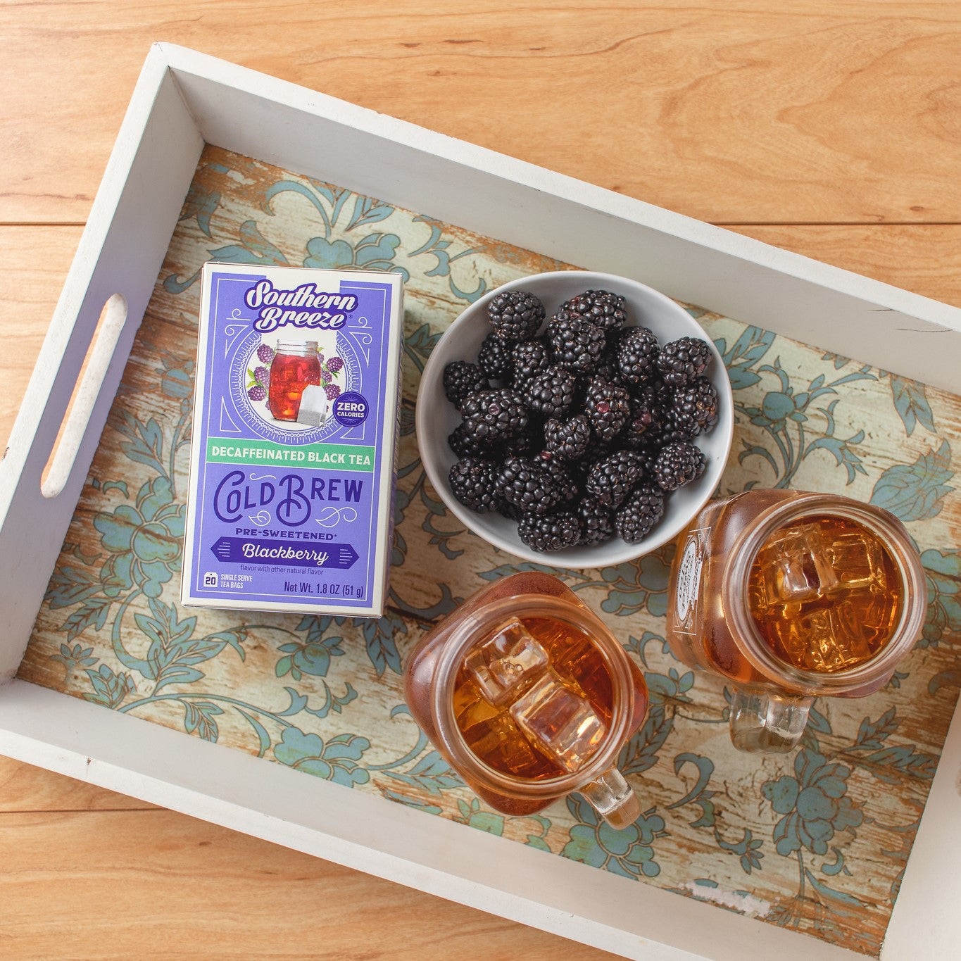 Southern Breeze Decaf Blackberry Sweet Iced Tea on a tray with jar of sweet tea and blackberries in a bowl
