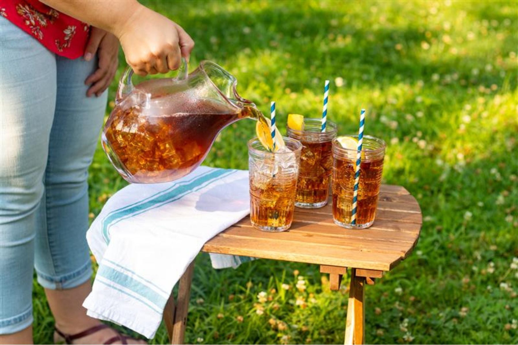A person pouring Southern Breeze Iced Tea in glasses