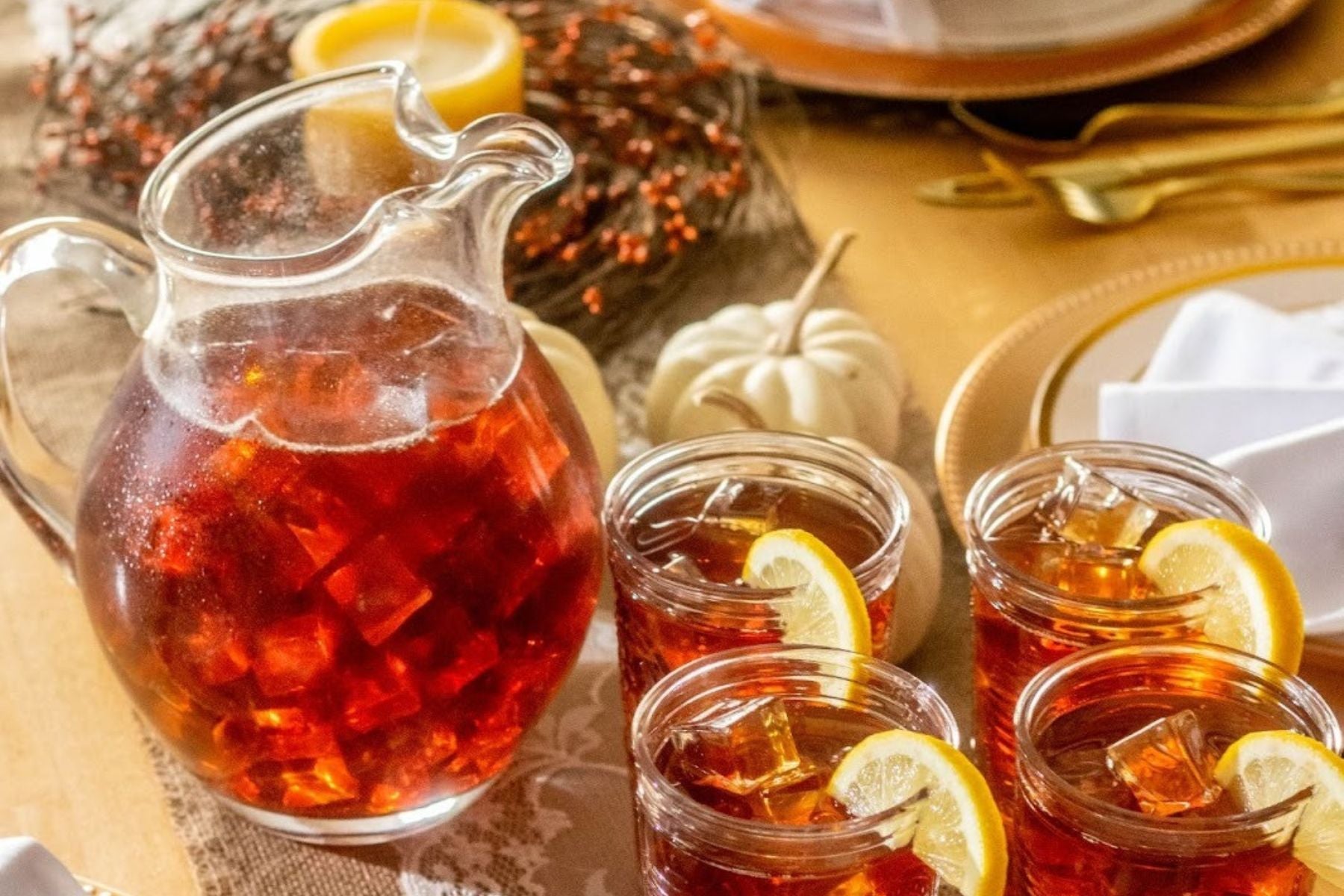 A pitcher of Iced Tea alongside four glasses of sweet teas