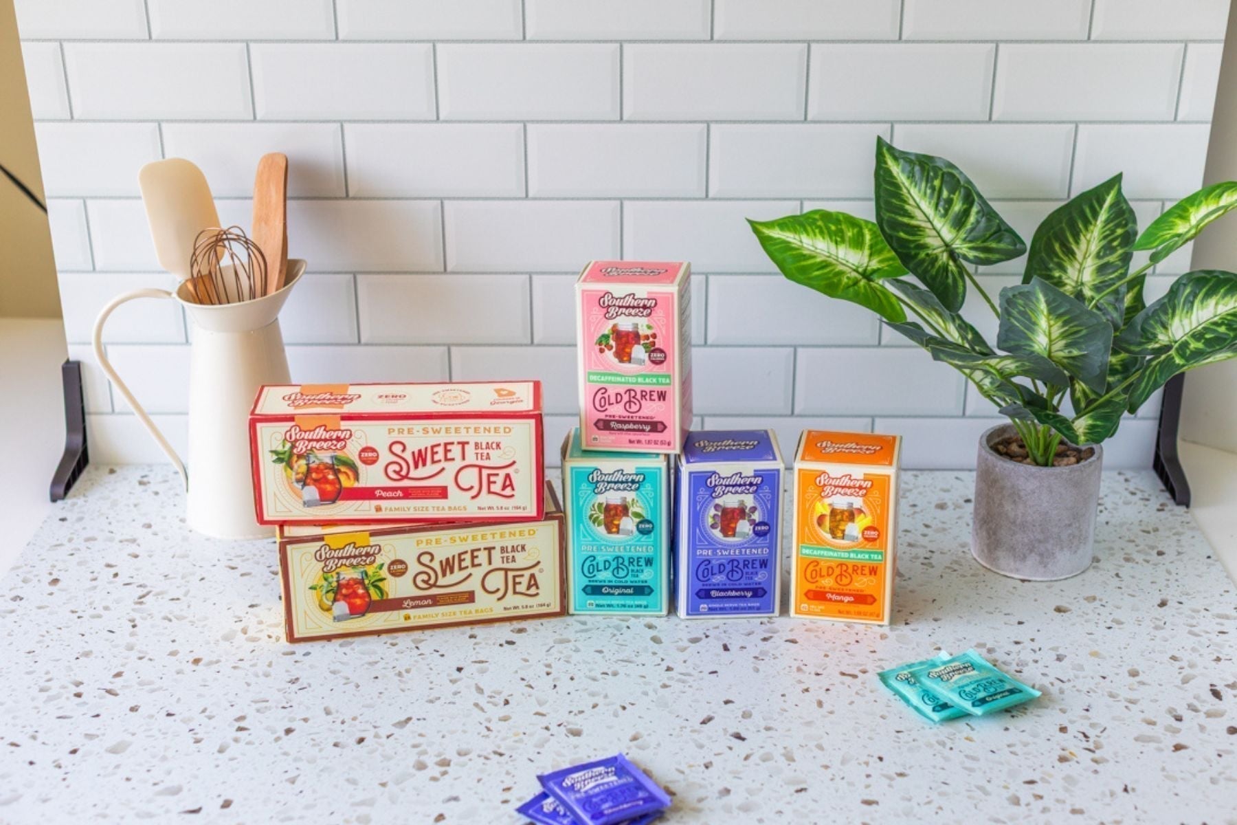 Assorted Southern Breeze sweet tea and cold brew boxes arranged on a kitchen counter with utensils and a plant