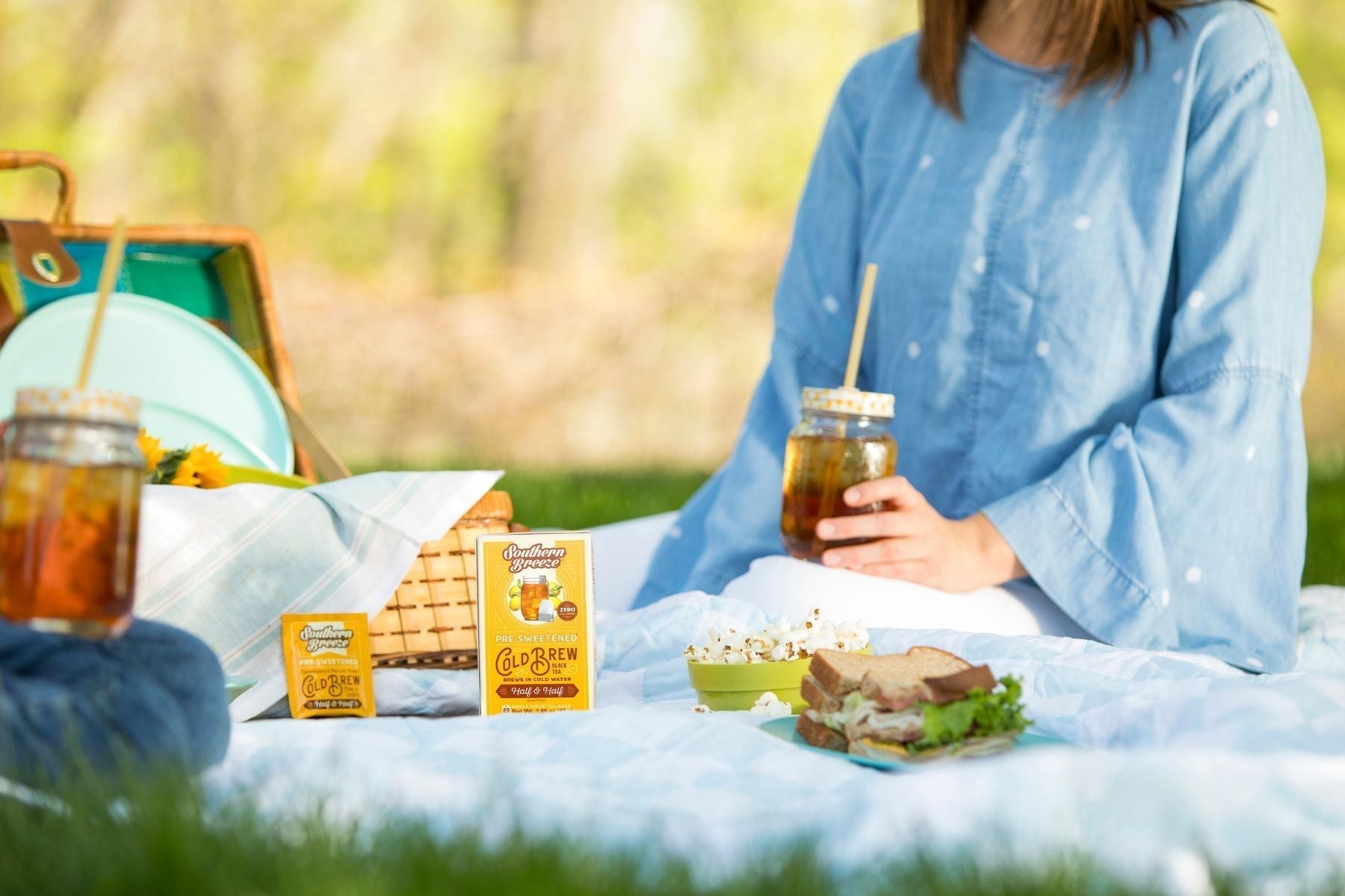 Outdoor picnic setup with Southern Breeze cold brew sweet tea, mason jar drinks, sandwiches, and snacks on a sunny afternoon blanket