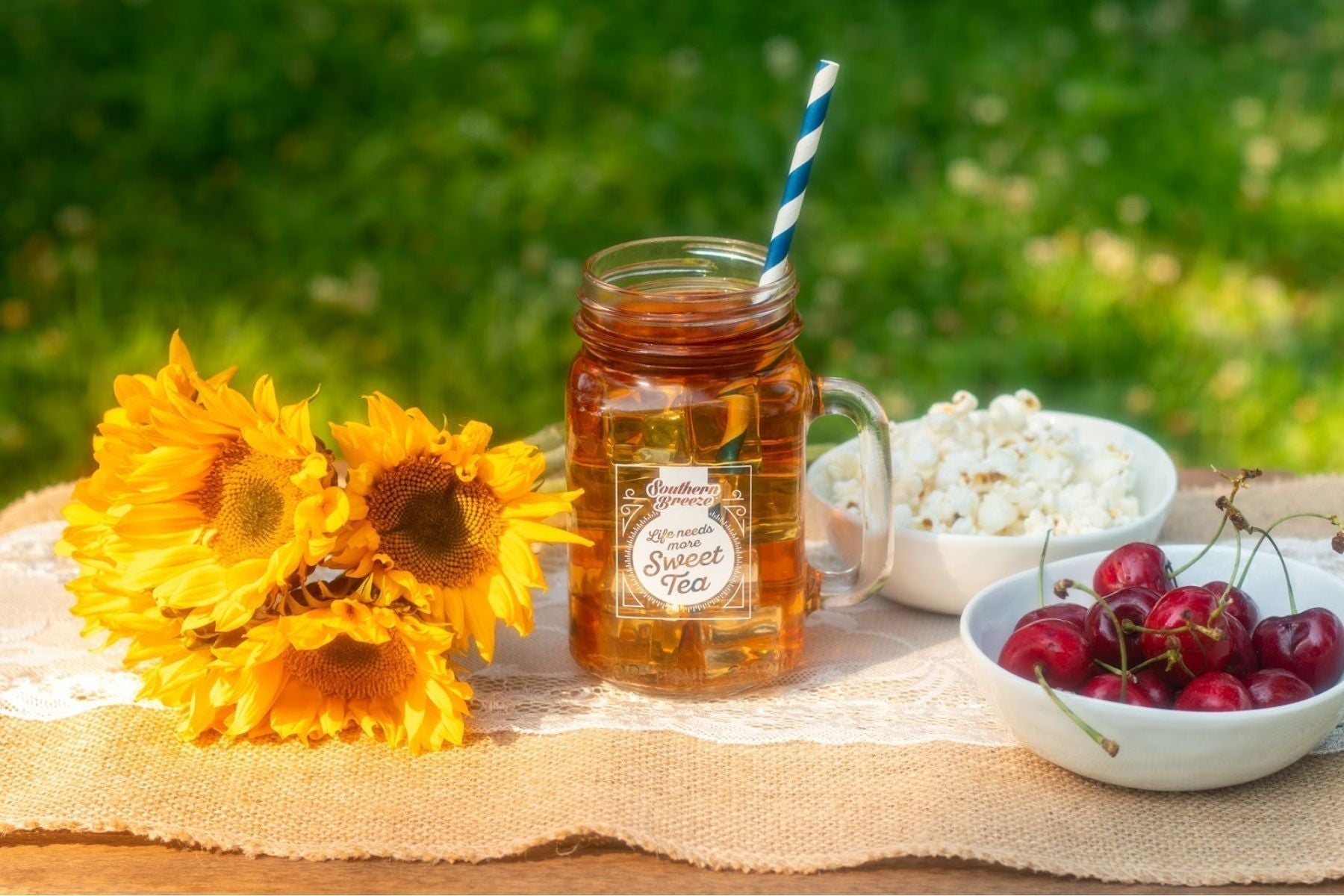 Overhead picnic scene with fruit, pie, popcorn, and Southern Breeze Cold Brew tea boxes.