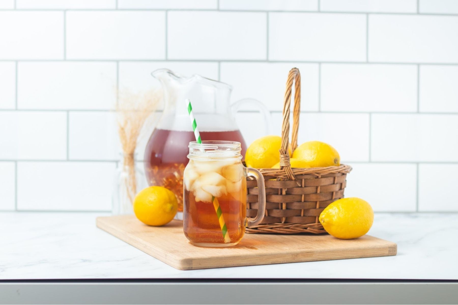 Iced tea mug, pitcher, and basket of lemons.