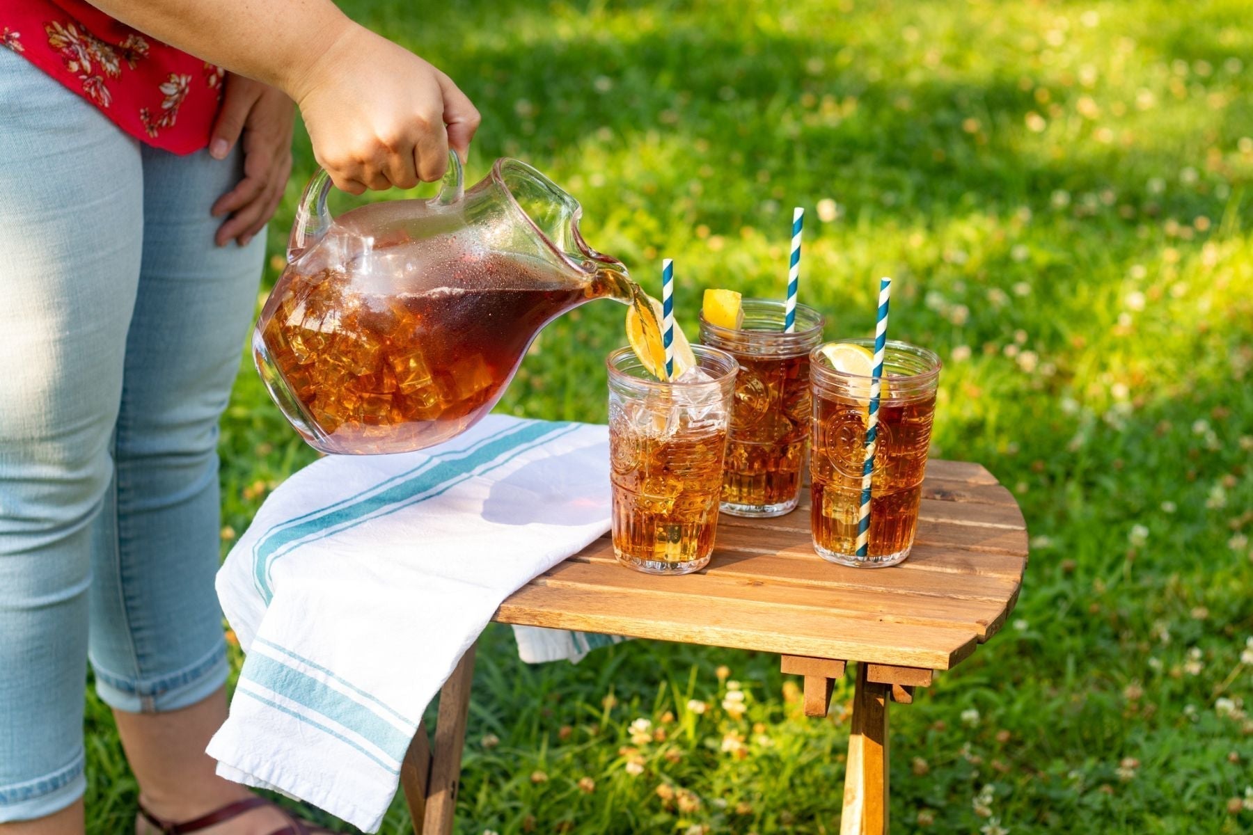 Iced tea being poured outdoors.