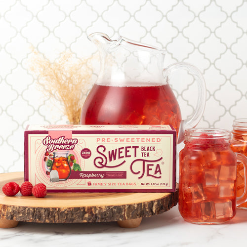 Southern Breeze Raspberry Sweet Iced Tea Family Size packaging with a pitcher and mugs on a decorative surface