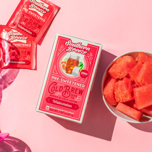 Southern Breeze Cold Brew tea packages with watermelon pieces on a pink background