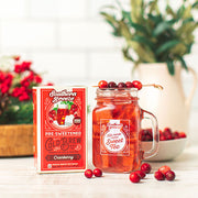 Southern Breeze Sweet Tea package with a glass of tea and cranberries on a table.