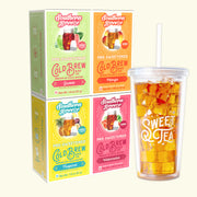 Four Southern Breeze Cold Brew tea boxes arranged in a 2x2 grid on a light cream background. The boxes are in Guava, Mango, Tropical, and Watermelon flavors, next to a clear plastic cup with a lid that says "Sweet Tea" and is full of sweet tea and ice.